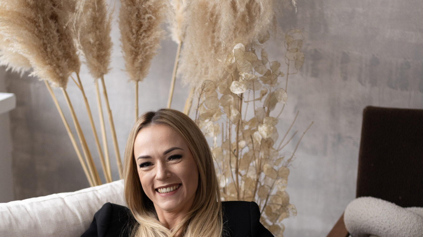 Justyna Bajer siedzi w fotelu i się śmieje